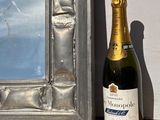 une bouteille de champagne à côté d'un cadre photo