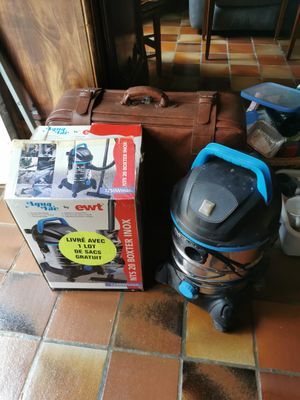 une valise et une bouteille d'eau posées par terre