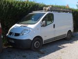 une camionnette blanche garée à côté d'une haie