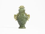 un vase vert posé sur une surface blanche
