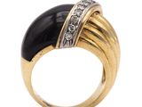 a close up of a gold ring with a black stone and diamonds