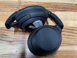 a close up of a pair of black headphones on a wooden surface