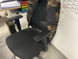 a chair with a camouflage jacket on it in front of a computer