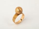 a close up of a gold ring on a white surface