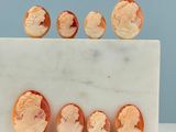 une image représentant un bloc de marbre sur lequel sont sculptés six types différents de camées