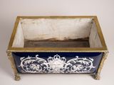 an antique blue and white planter with gold trimming