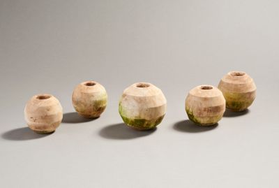 quatre vases en bois sont alignés sur une surface grise