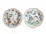 two plates with birds and flowers painted on them on a white surface