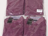 four purple shirts are wrapped in plastic bags on a table