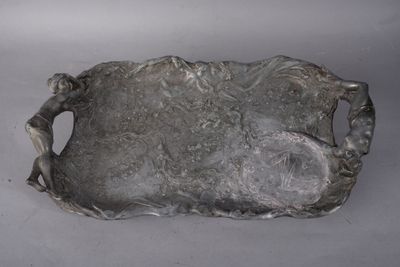 a silver tray with a statue on it on a table
