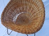 an image of a wicker chair sitting on a metal stand