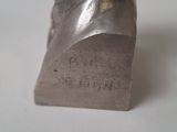statue of a man ' s head made of metal on a white surface