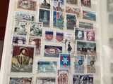 une personne tenant un livre sur lequel figurent des timbres