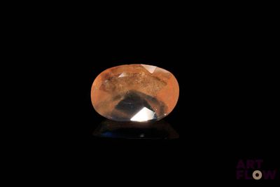 a close up of a yellow and black diamond on a black surface