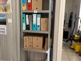 a shelf full of boxes and papers in a room