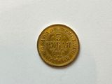 a close up of a gold coin on a white surface