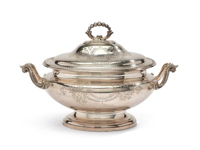une soupière ancienne en métal argenté avec couvercle, posée sur un socle