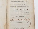 un livre ouvert, sur lequel figure un titre écrit à la main, posé sur une table
