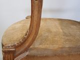 a wooden chair with a tan upholstered seat