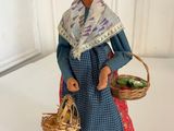 figurine of a woman with a basket of vegetables in her hands