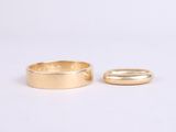two gold wedding rings on a white background
