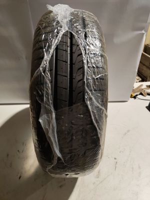 un gros plan d'un pneu de voiture emballé dans du plastique, posé sur une table