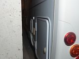 a white bus that is parked next to a building