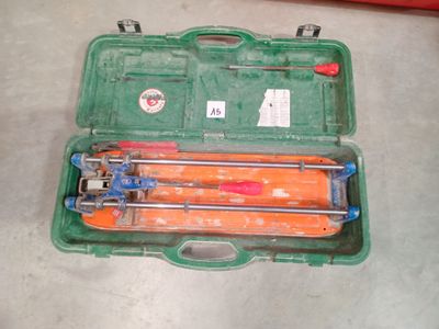 une mallette verte posée par terre, contenant des outils