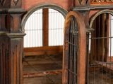 a wooden bird cage with a bird inside of it
