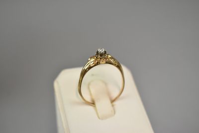 an image of a gold ring with a diamond on top of a white box