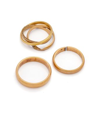three gold wedding rings on a white background