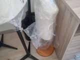 a white mannequin sitting on a stand next to a table