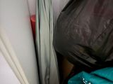a box of clothes and an umbrella in the corner of a room