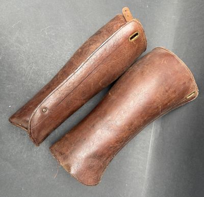 pair of brown leather riding boots on a gray surface