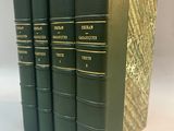 four green books sitting on top of each other on a white surface