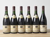 six bouteilles de vin sont alignées sur une table en bois
