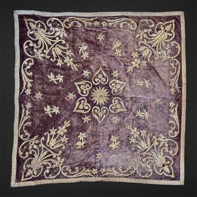 un gros plan sur un tapis violet et doré sur fond noir