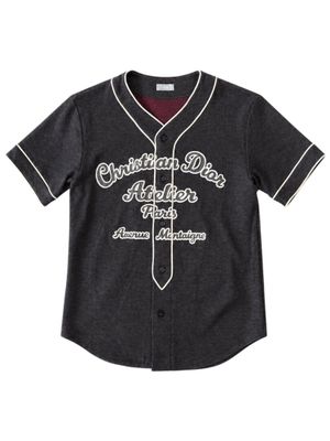 the children ' s baseball jersey is black and has a white logo on it