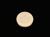 a silver coin sitting on top of a black surface