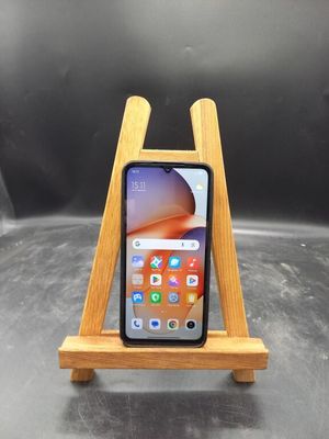 un gros plan d'un téléphone portable posé sur un support en bois