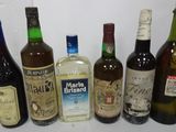 many bottles of alcohol lined up on a shelf