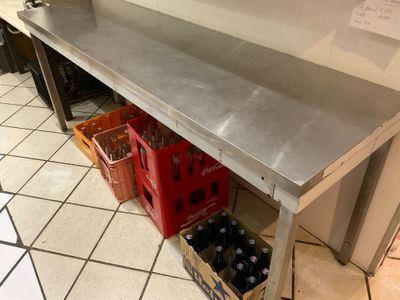 a stainless steel table with a bunch of bottles on it