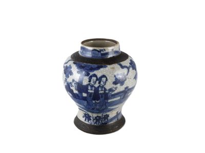 un vase bleu et blanc sur lequel sont représentées deux personnes