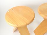 pair of wooden stools on a white surface with a white background