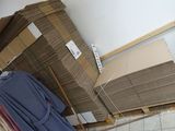 a pile of boxes on a pallet next to a pile of clothes