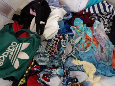 une pile de vêtements posée sur un lit