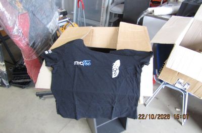 un t-shirt noir posé sur une boîte en carton