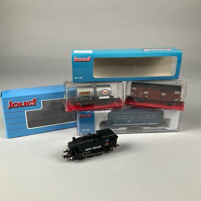 trois trains miniatures dans leurs boîtes, posés les uns à côté des autres sur une table
