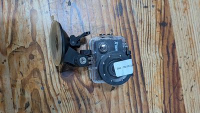 un gros plan d'un appareil photo posé sur un parquet