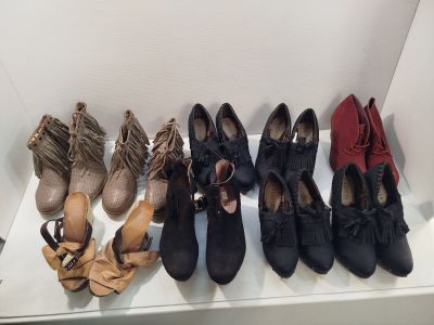 Plusieurs paires de chaussures pour femmes sont alignées sur une étagère